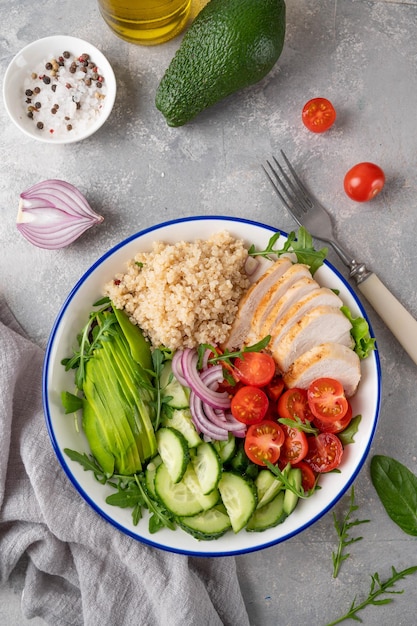 Gezonde bowl lunch met gegrilde kip quinoa avocado tomaten komkommers en verse rucola