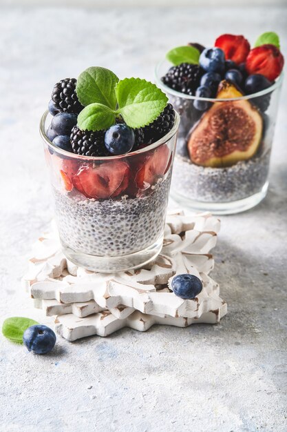 Gezonde chia pudding met aardbeien, bramen, bosbessen en vijgen geserveerd in een glas