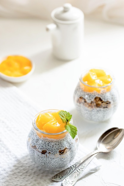 Gezonde chia pudding met kokosmelk mango chia zaden granola in een glas concept van gezond eten
