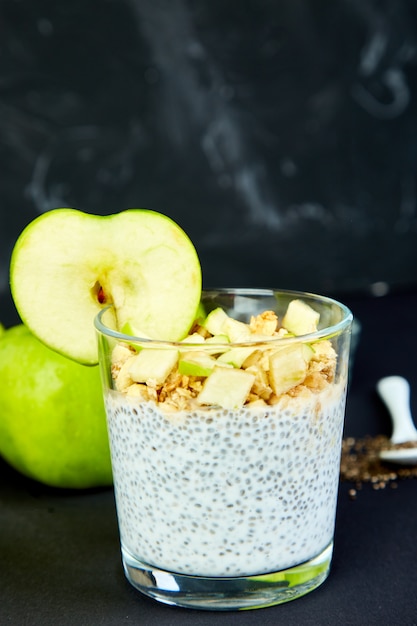 Gezonde chiapudding met appelen en granola in glas.