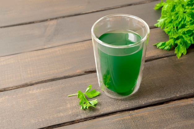 Gezonde detox drink chlorofyl extract met water in een glazen beker op houten tafel met kopieerruimte
