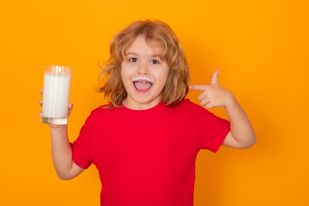 Gezonde drank met calcium en eiwit voor kinderen Kind met glas melk geïsoleerd op gele studio achtergrond