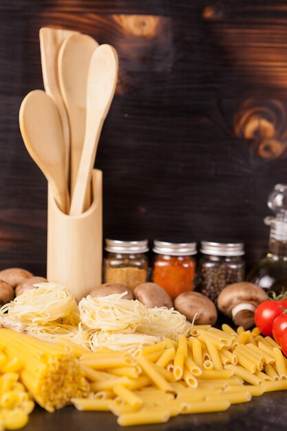 Gezonde en heerlijke maaltijd - rauwe ongekookte pasta naast groenten op rustieke vintage houten achtergrond