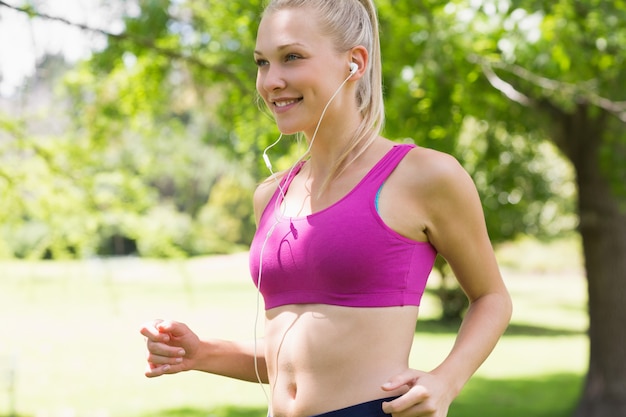 Gezonde en mooie jonge vrouw in sport BH joggen in het park