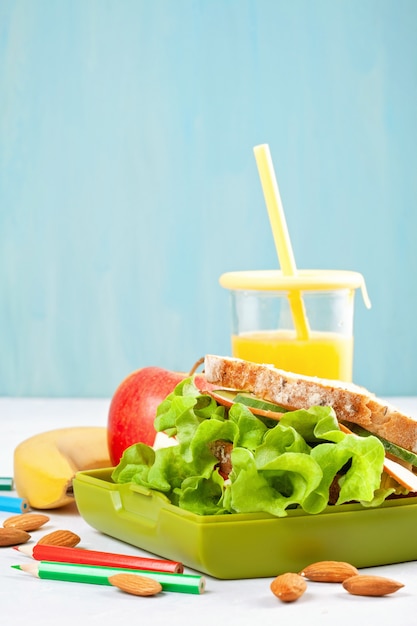 Foto gezonde en verse sandwich, appel en sinaasappelsap voor studentenlunch