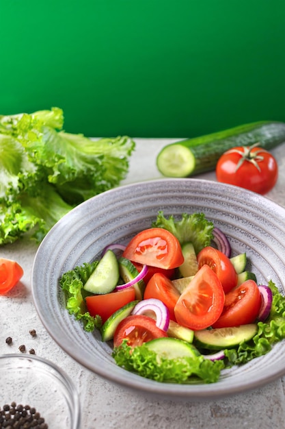 Foto gezonde fitness verse eenvoudige salade gezonde voeding groente groene salade komkommers tomaten uien verticale banier