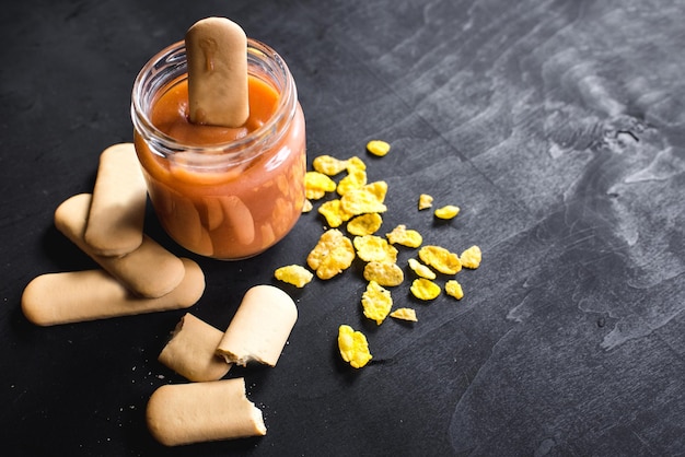 Gezonde fruityoghurt of puree in glas op zwarte achtergrond