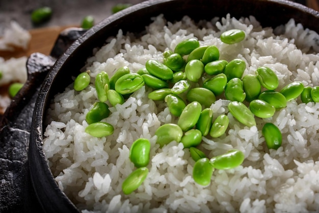 Gezonde Fusion Top Close-up van Edamame geserveerd op gestoomde witte rijst in een gietijzeren pot in 4k