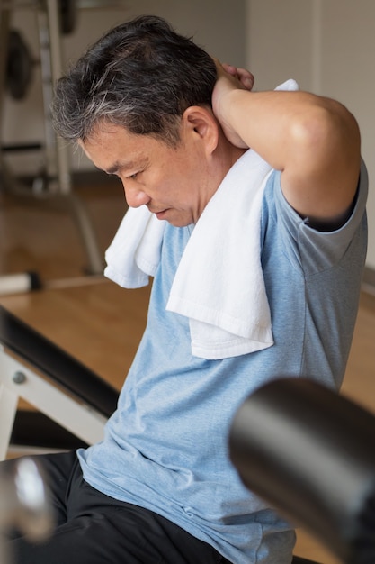 Gezonde gelukkig lachend positieve senior welzijn aziatische man ab spier in sportschool uit te werken