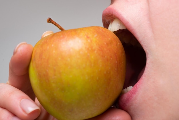 Gezonde gelukkige vrouw die appel dichte macro eet. een appel bijten. mond close-up. tandheelkunde.