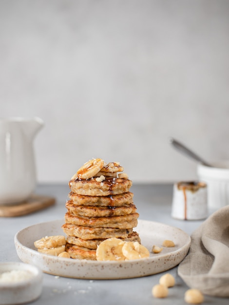 Gezonde gemakkelijk ontbijt havermout banaan pannenkoeken met dadelsiroop grijs oppervlak,