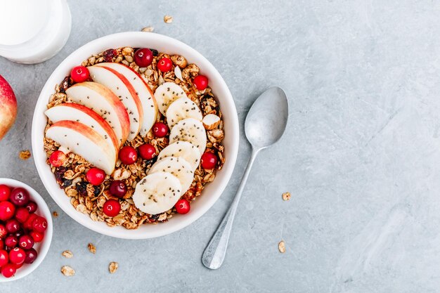 Gezonde granola-ontbijtkom met appel-cranberry-banaan en chiazaden Bovenaanzicht kopieerruimte