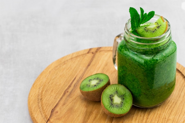 Gezonde groene smoothie met spinazie en kiwi in een pot mok