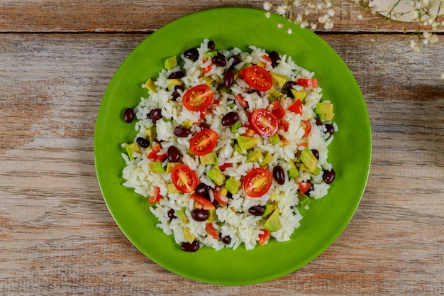 Gezonde groene vegetarische lunch met rijst, tomaat, avocado op tafel.