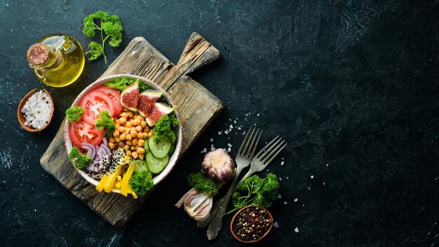 Gezonde groente buddha bowl lunch met kikkererwten vijgen komkommer tomaten en uien Gerechten menu Gratis kopieerruimte Bovenaanzicht