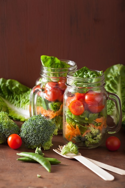 Gezonde groentesalade in metselaarkruik. tomaat broccoli wortel erwt