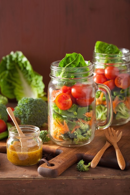 Gezonde groentesalade in metselaarkruik. tomaat broccoli wortel erwt