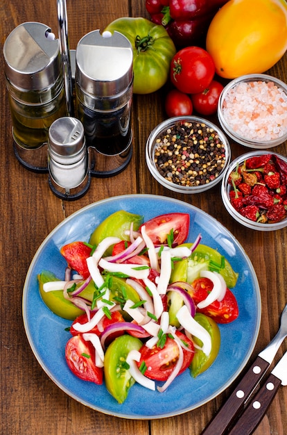 Gezonde groentesalade met tomaten en inktvisstukjes. Studiofoto.