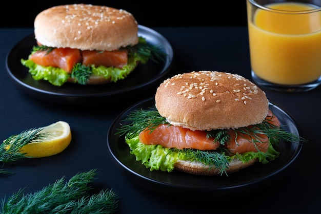 Gezonde hamburger met gezouten zalm en jus d'orange op donkere achtergrond