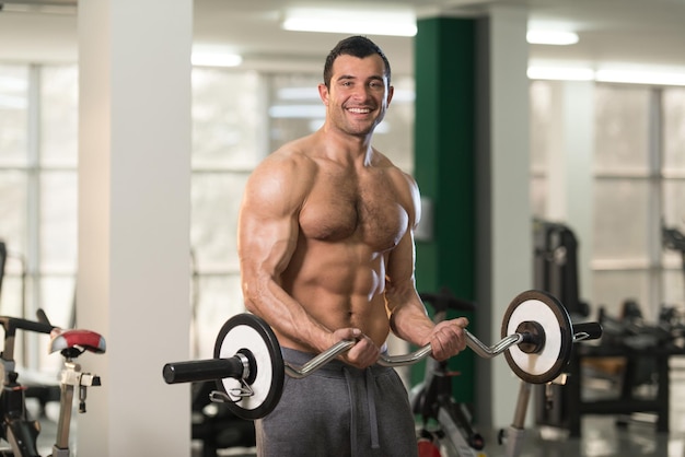 Gezonde harige man die biceps traint in een sportschool in het fitnesscentrum