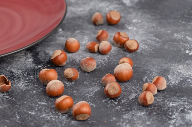 Gezonde hazelnoten in de dop op een stenen tafel.