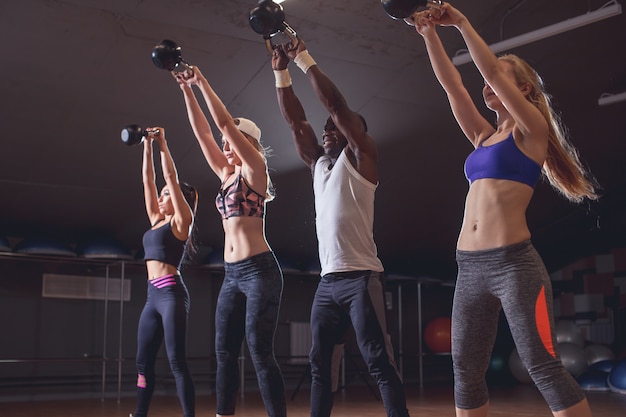 Gezonde jonge atleten die oefeningen met kettlebells doen, bij geschiktheidsstudio