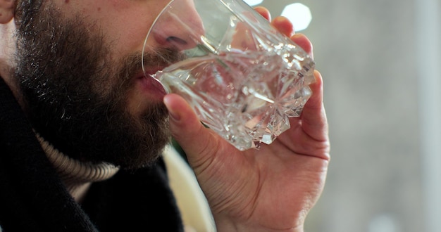 Gezonde jonge man met glas drinken van vers transparant water, man hydraterende dorst houden dieet voeding gewichtsverlies gezondheidszorg natuurlijke balans concept, close-up.