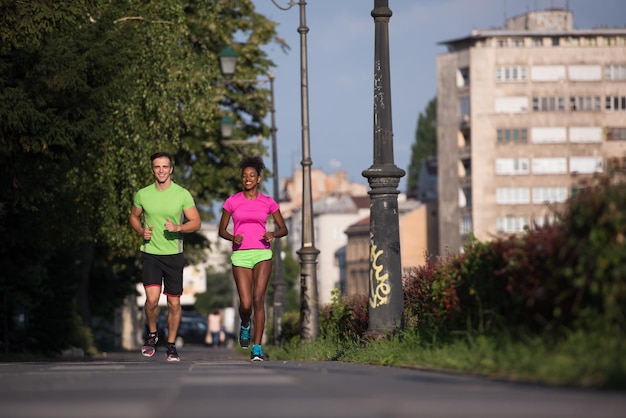 gezonde jonge multi-etnische paar joggen in de stad op een zonnige zomerdag
