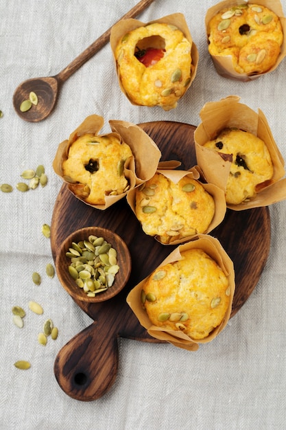 Gezonde kaasmuffins met polenta, kerstomaatjes en pompoenpitten als ontbijt. Selectieve aandacht. Bovenaanzicht. Kopieer ruimte.