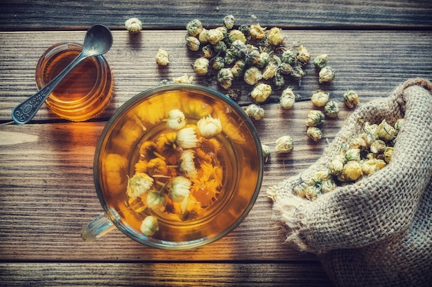 Gezonde kamille theekop jute zak met droge madeliefjebloemen en honingpot Bovenaanzicht