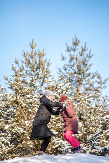 Gezonde levensstijl Actief kind Prettige kerstdagen Een meisje met haar moeder voor een wandeling in het winterpark