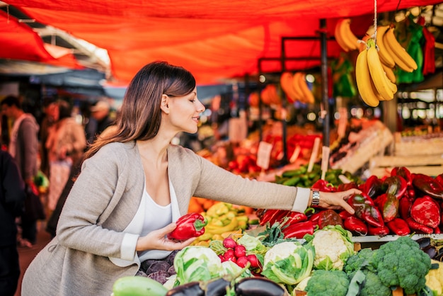 Gezonde levensstijl. Charmante vrouw het kopen van groenten op boerenmarkt.