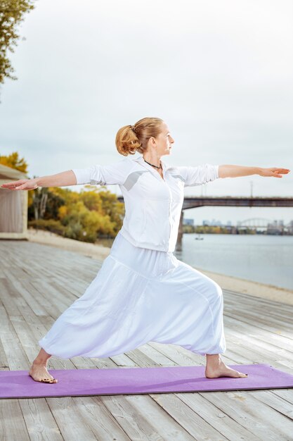 Gezonde levensstijl. jonge vrouw beoefenen van yoga tijdens het doen van ochtendoefeningen buiten