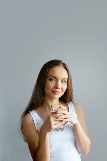 Gezonde levensstijl. Jonge vrouw drinken uit een glas vers water