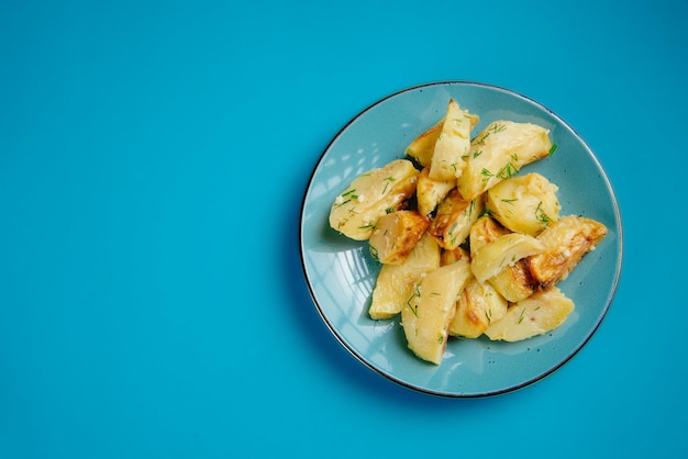 Gezonde levensstijl, juiste voeding verbod op ongezond voedsel, gebakken aardappelen in een bord op een blauwe achtergrond