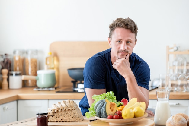 Gezonde man in de kitcken met gezond voedsel op de tafel