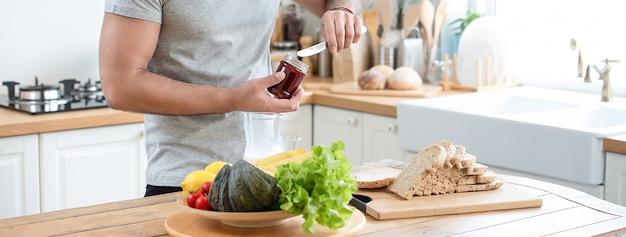 Gezonde mensen preaparing ontbijtsandwich in keuken thuis