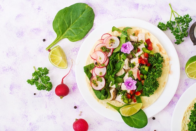 Gezonde Mexicaanse graantaco&#39;s met gekookte kippenborst, spinazie, radijs en paprika.