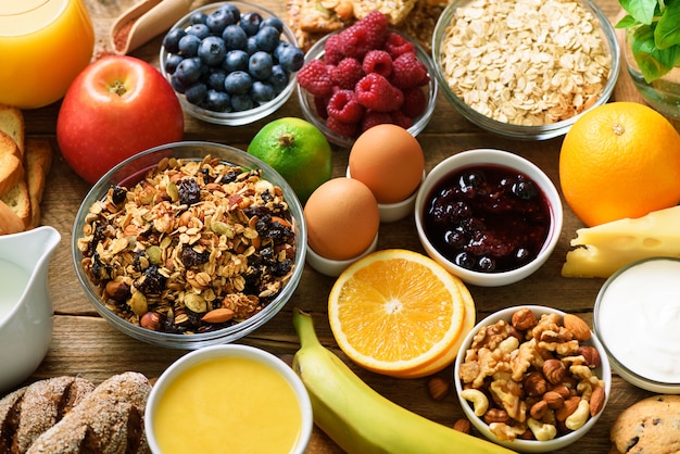 Gezonde ontbijtingrediënten, voedselkader. muesli, eieren, noten, fruit, bessen, toast, melk, yoghurt, jus d'orange, kaas, banaan, appel