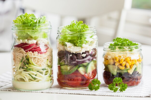 Gezonde plantaardige kaassalade in metselaarkruiken