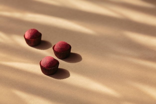 Gezonde rauwe energieballen met cacao op een beige achtergrond