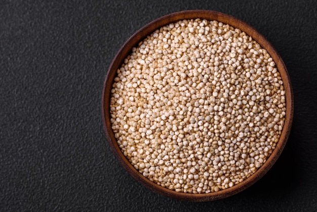 Gezonde rauwe quinoa in een kom op een donkere betonnen achtergrond