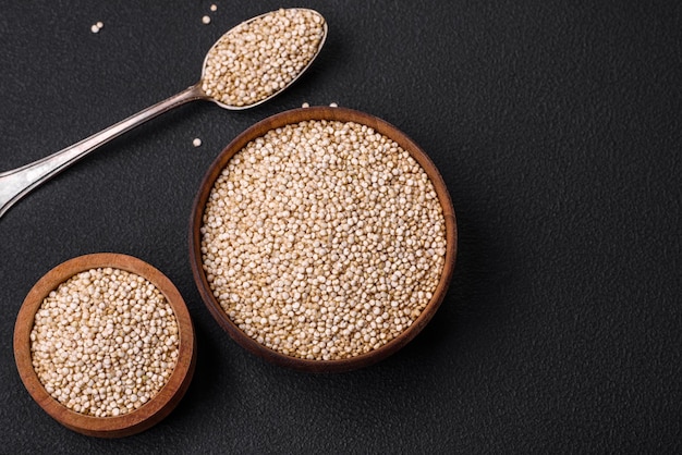 Gezonde rauwe quinoa in een kom op een donkere betonnen achtergrond