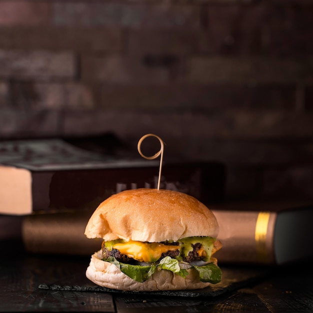 Foto gezonde rundvleesburger met sla bladeren ui tomaten en gesmolten kaas geserveerd in een schotel geïsoleerd op een houten tafel zijbeeld van arabisch eten