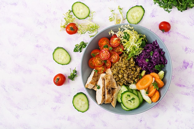 Gezonde salade met kip, tomaten, komkommer, sla, wortel, selderij, rode kool en mungboon op Lichttafel.