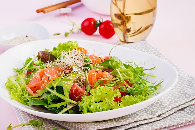 Gezonde salade met verse groenten, tomaten, avocado, rucola, zaden en zalm