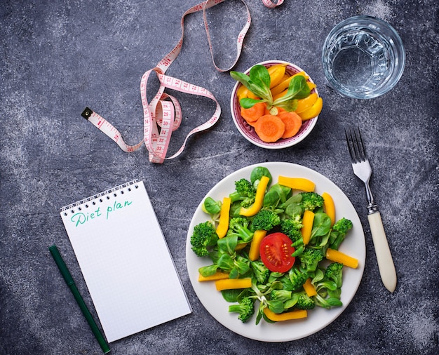 Gezonde salade, schoon water en meetlint.