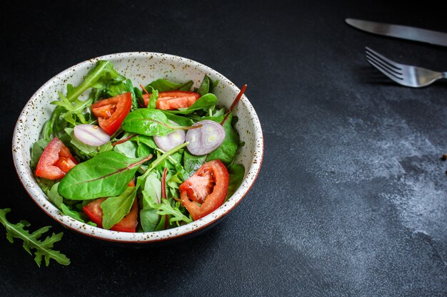 Gezonde salade tomaat, mix bladeren, uien en andere ingrediënten