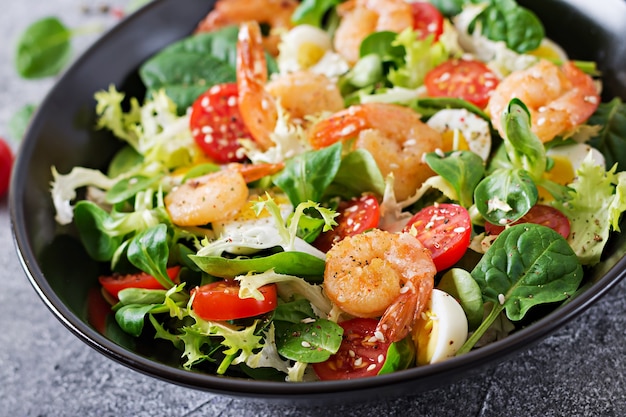 Gezonde saladeplaat. Vers zeevruchtenrecept. Gegrilde garnalen en verse groentesalade en ei. Gegrilde garnalen. Gezond eten.
