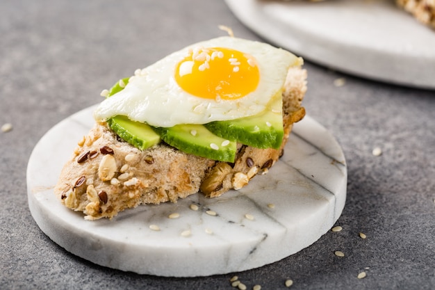 Gezonde sandwich met verse avocado en gebakken kwarteleitjes